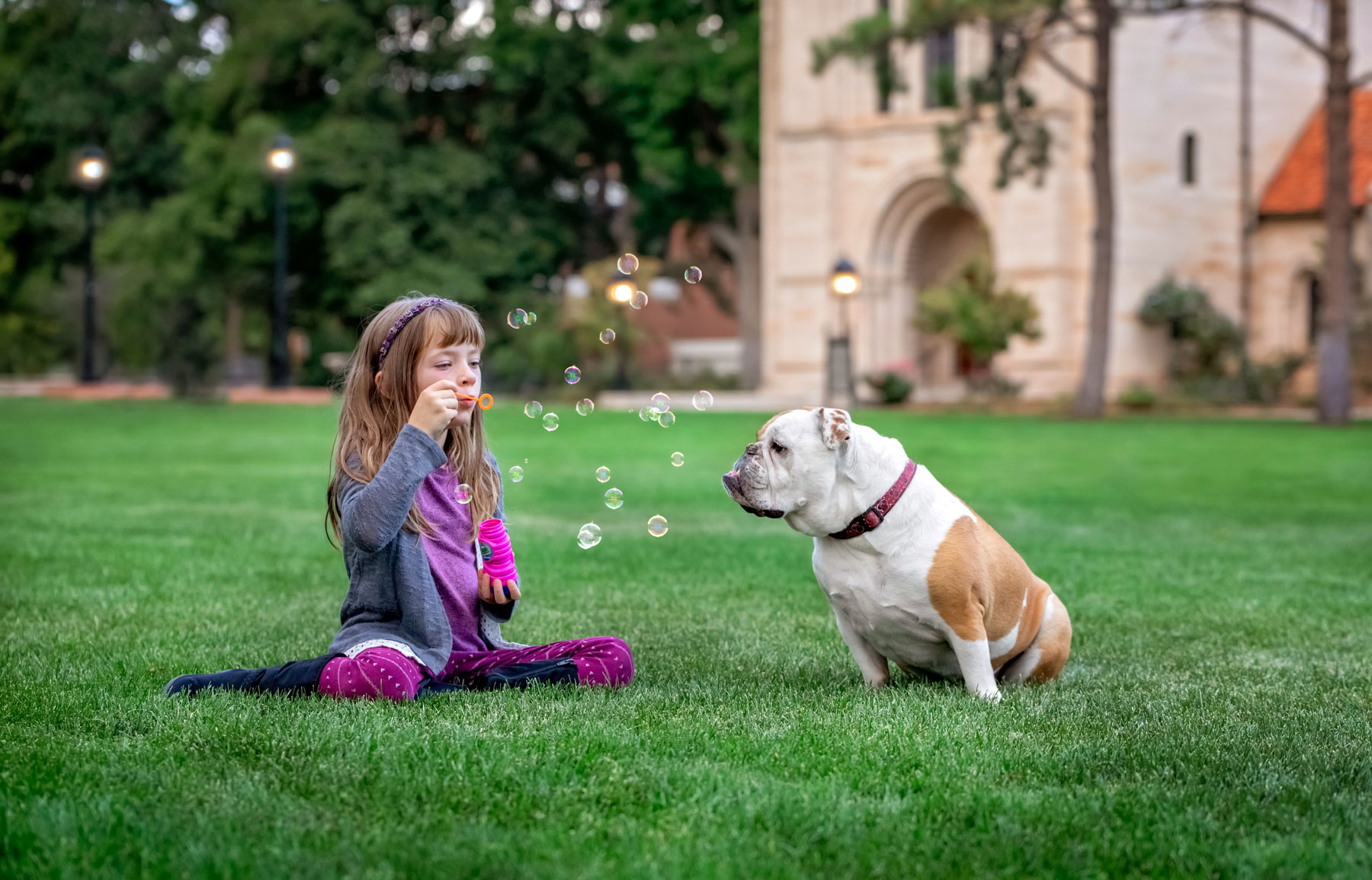 Girl blowing bubbles at her dog